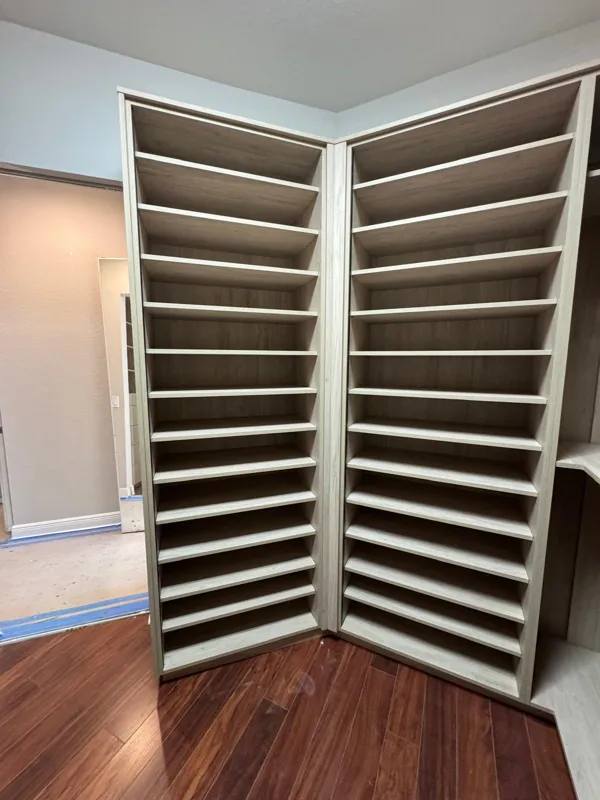 Walk-in closet with twin shoe towers in light oak