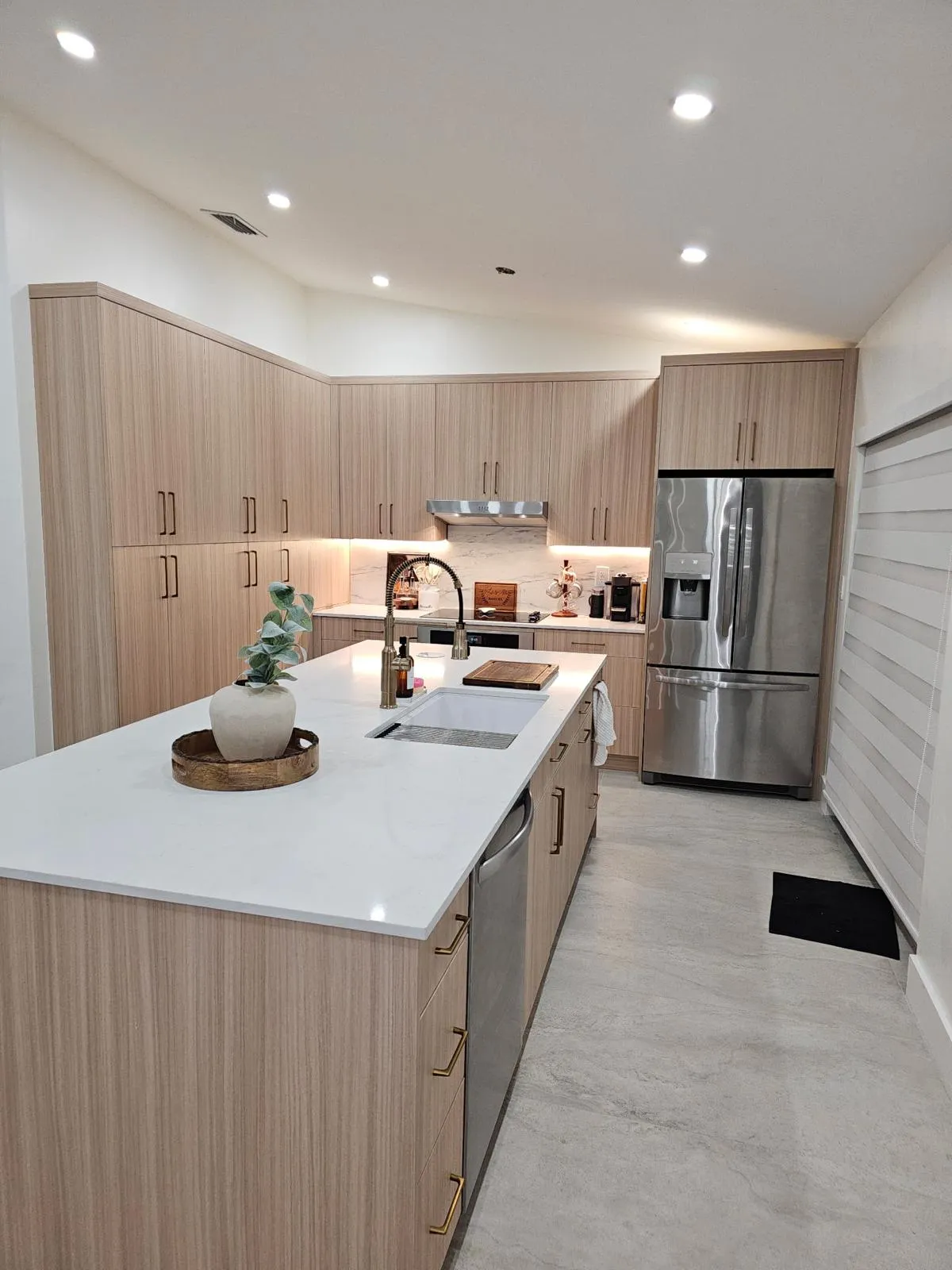 Light oak kitchen with under-cabinet lighting and a white island